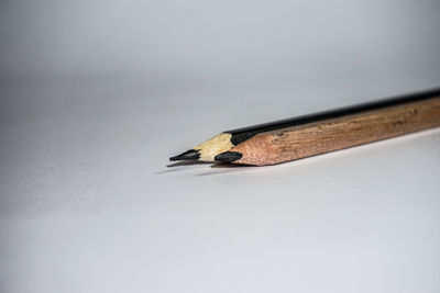 Close-up of colored pencils on wood against white background