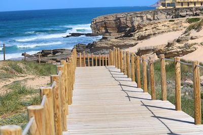 Wooden posts on beach against sky