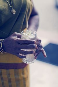 Holding blessing water glass by mother 