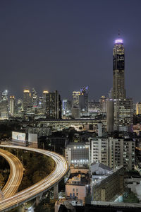 Illuminated cityscape against sky at night