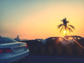 Cars on car against sky during sunset