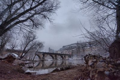 Bridge over river against sky during winter