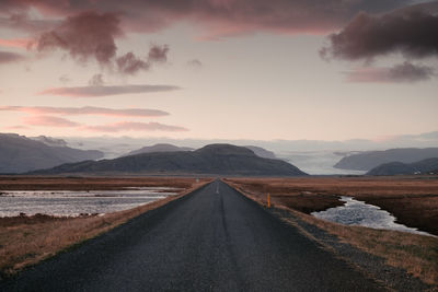 Diminishing perspective of empty road against sky during sunset