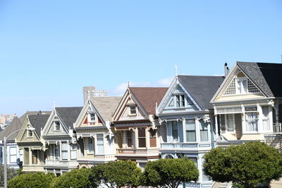 Low angle view of houses against clear blue sky