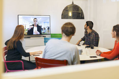 Creative business people attending conference call in board room