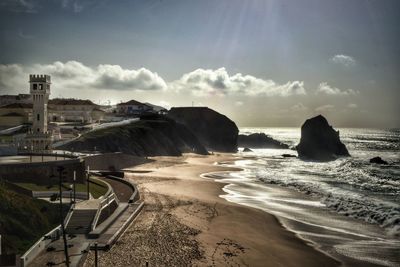 Scenic view of sea against cloudy sky on sunny day