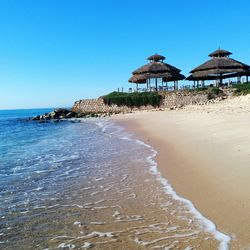 Built structure on beach against clear blue sky