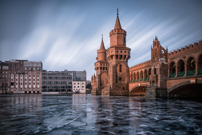 Bridge over river against buildings in city