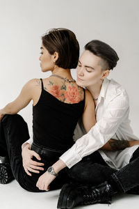 Young woman looking away while sitting on floor