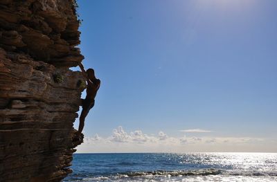 Scenic view of rocks by sea against sky