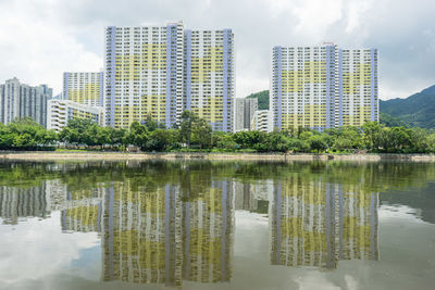 Reflection of buildings in lake against sky