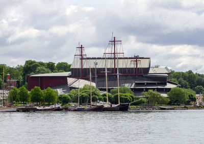 Sailboats in river against sky