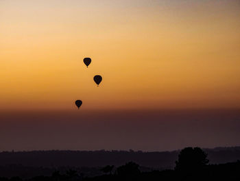 Silhouette hot air balloon against sky during sunset