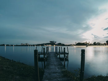 Pier on lake against sky at dusk