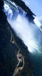 Scenic view of waterfall against sky