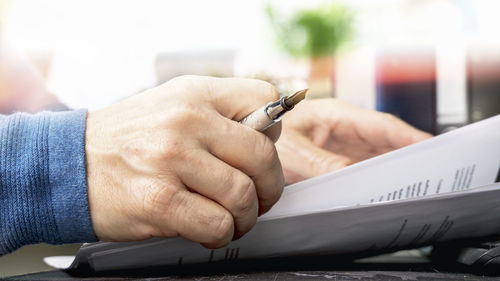 Midsection of man holding paper