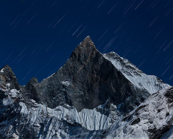 Scenic view of snowcapped mountains against sky at night