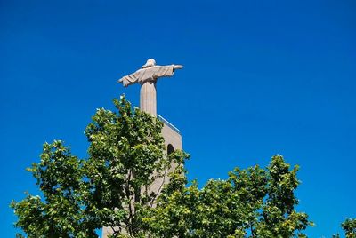 Low angle view of statue against clear blue sky