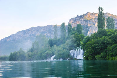 Scenic view of lake by mountain against sky