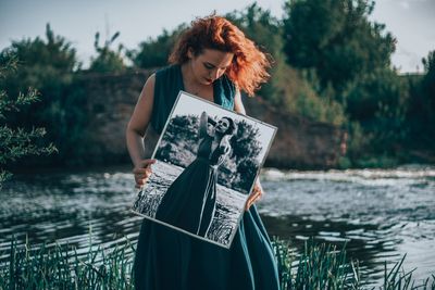 Woman standing against lake