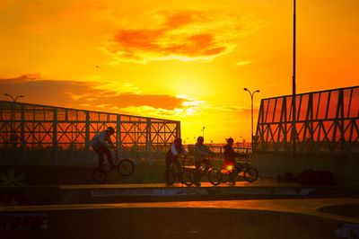 People at observation point against sky during sunset