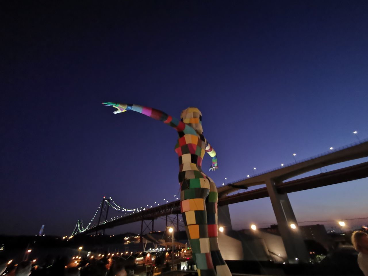 LOW ANGLE VIEW OF ILLUMINATED BRIDGE AT NIGHT