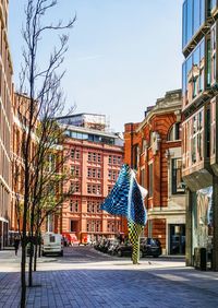 Street amidst buildings against sky in city