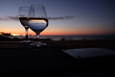 Close-up of wineglass on table at beach