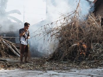 Young man standing by plants