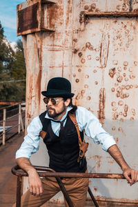 Full length of man wearing hat standing against wall