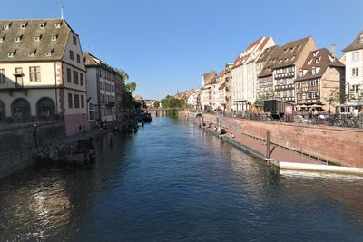 Canal amidst buildings against sky in city