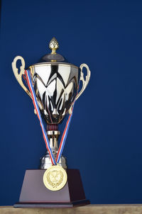 Close-up of trophy against blue wall