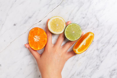 Cropped image of hand holding orange fruit