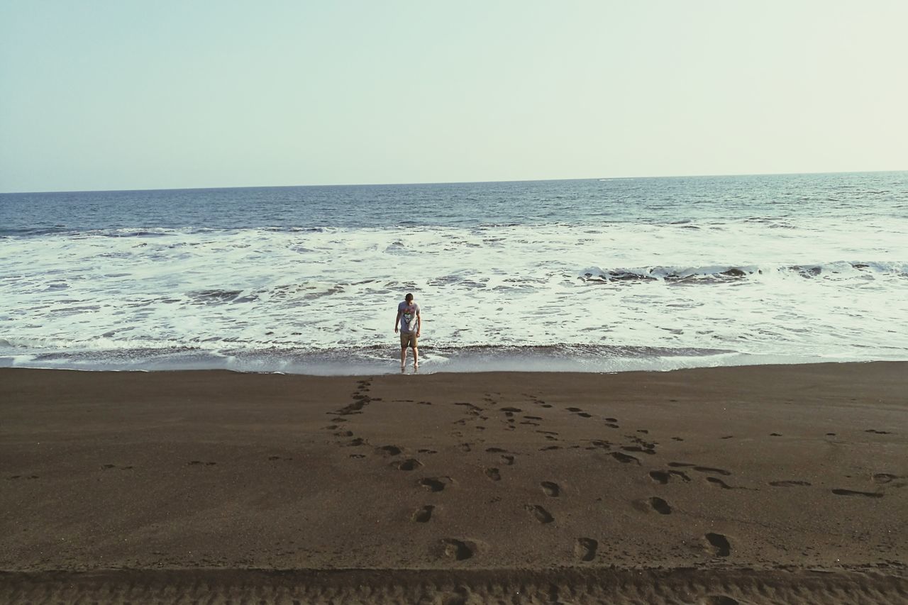 MAN AT BEACH AGAINST CLEAR SKY