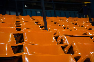 Close-up of orange empty chairs