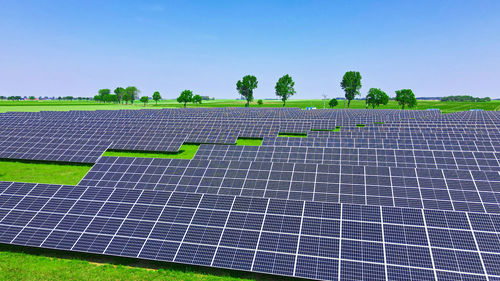 Solar panels in green field, aerial view