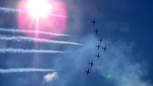 Low angle view of vapor trails against blue sky