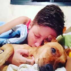 Portrait of man with dog lying on bed