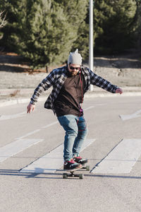 Full length of man skateboarding on road