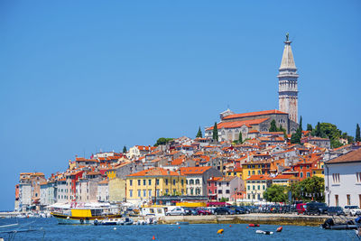 Buildings in town against clear blue sky