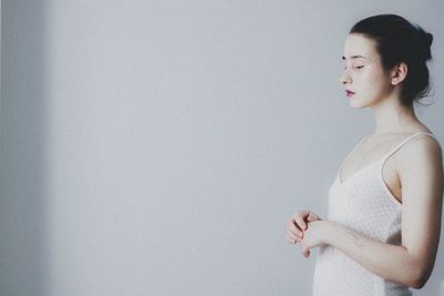 Young woman looking away against white background