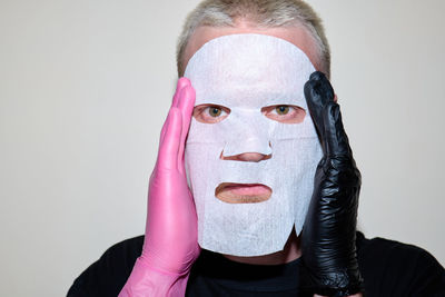 Portrait of woman wearing mask against white background