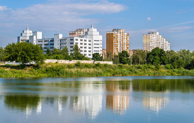 Lake by buildings against sky in city