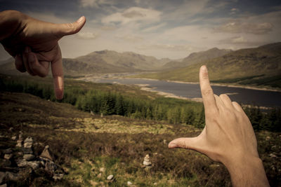 Human hands against mountain range 