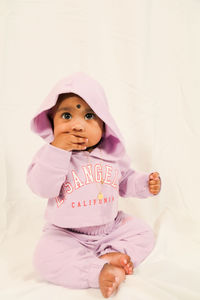Portrait of cute baby boy lying on bed at home