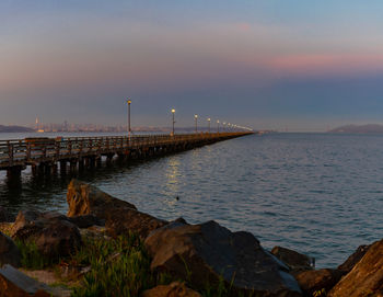 Scenic view of bay against sky at sunset