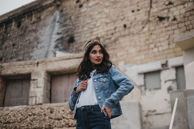 Portrait of woman standing against wall