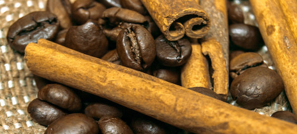 Full frame shot of coffee beans and cinnamon stick 