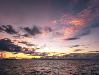 Scenic view of sea against dramatic sky during sunset