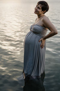 Woman looking away while standing in water